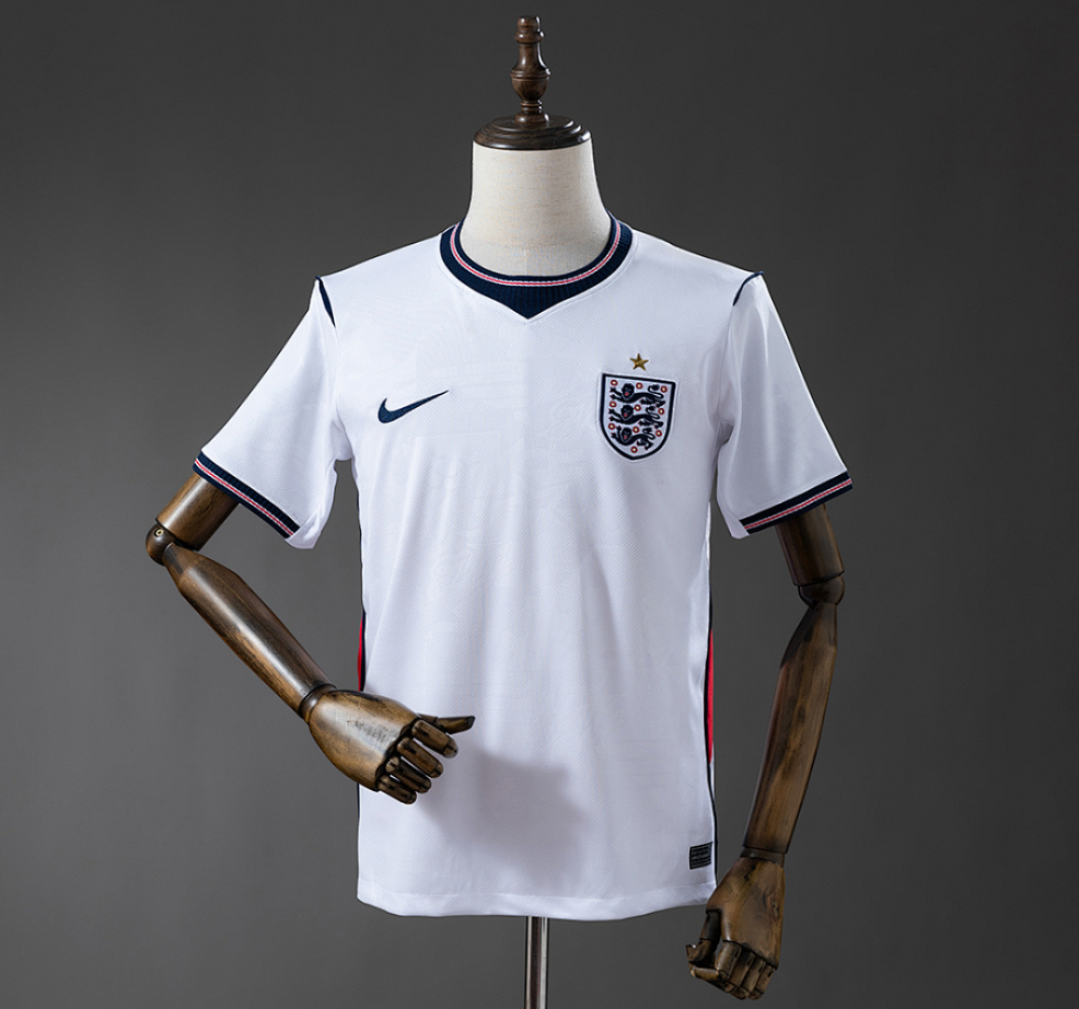 White sports jersey with a logo on a mannequin against a gray background.England 2026 Home Jersey