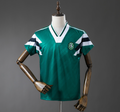 Green sports jersey with white and black stripes on a mannequin against a gray background, Sporting Lisbon Retro-Green Jersey. 11CULTURE