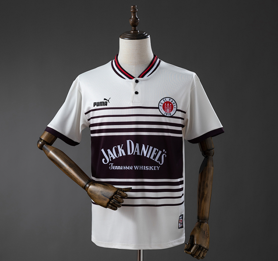 White sports jersey with black stripes and Jack Daniel's branding on a mannequin against a gray background