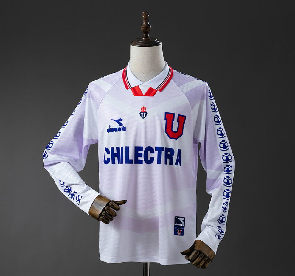 White sports jersey with red and blue accents on a mannequin against a dark background, Universidad de Chile 1996 Away Jersey Long Sleeve, 11culture, original chile jersey, retro jersey